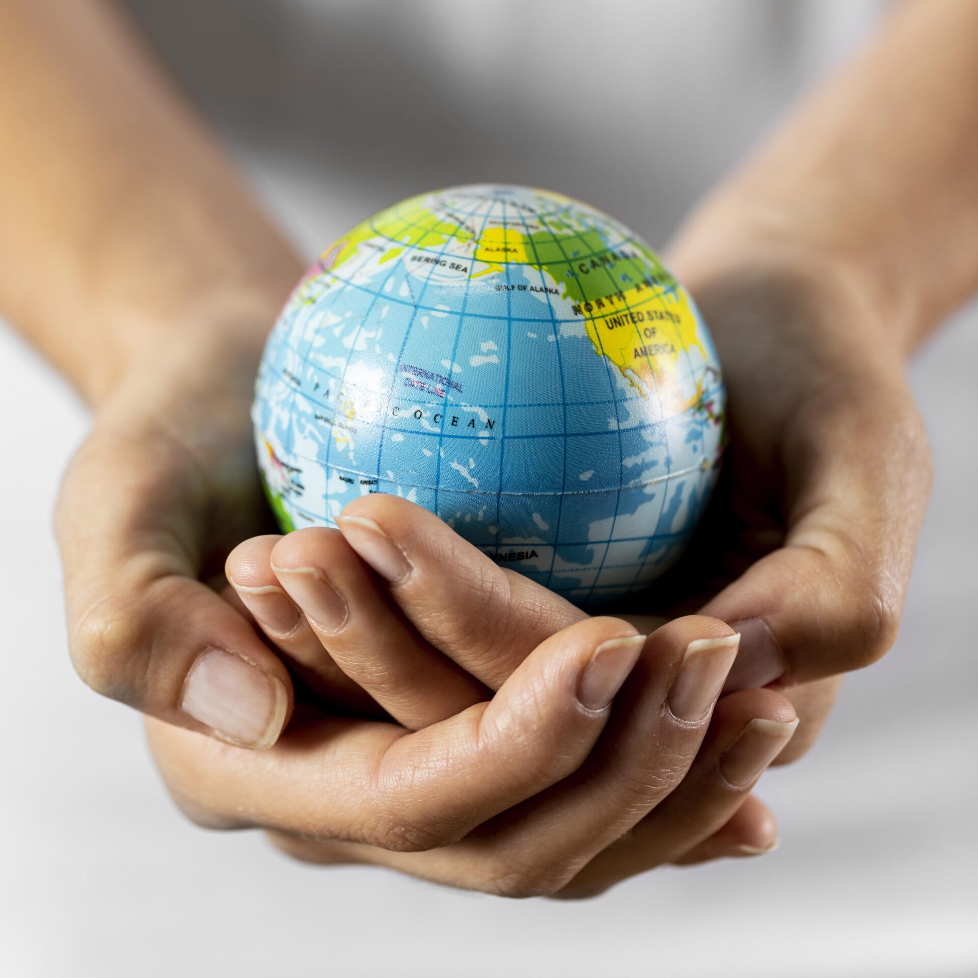 Mãos segurando um globo terrestre, representando a contribuição para um planeta mais sustentável